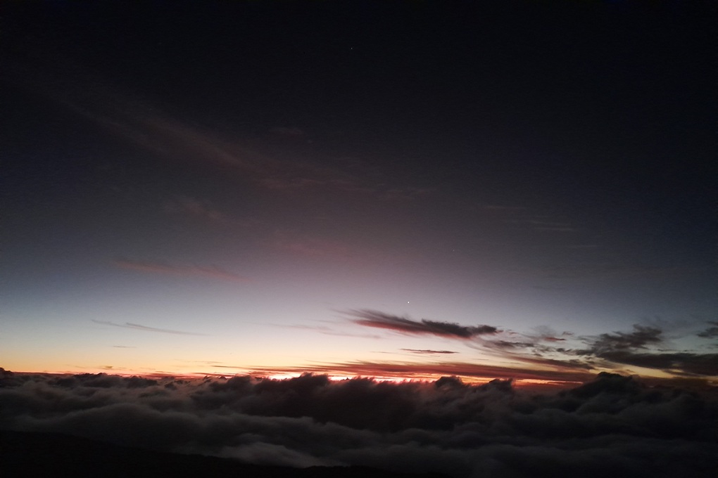 night sunset in La Réunion, with a dark sky and final red glimmers above a sea of clouds