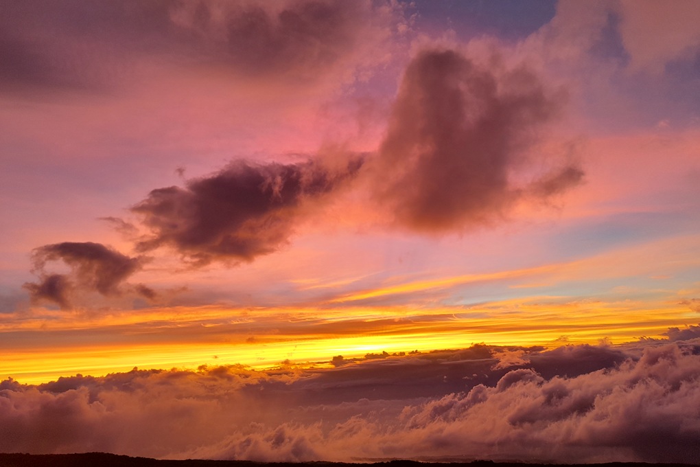 colourful sunset in La Réunion, with pink clouds and a luminous orange sky above the ocean