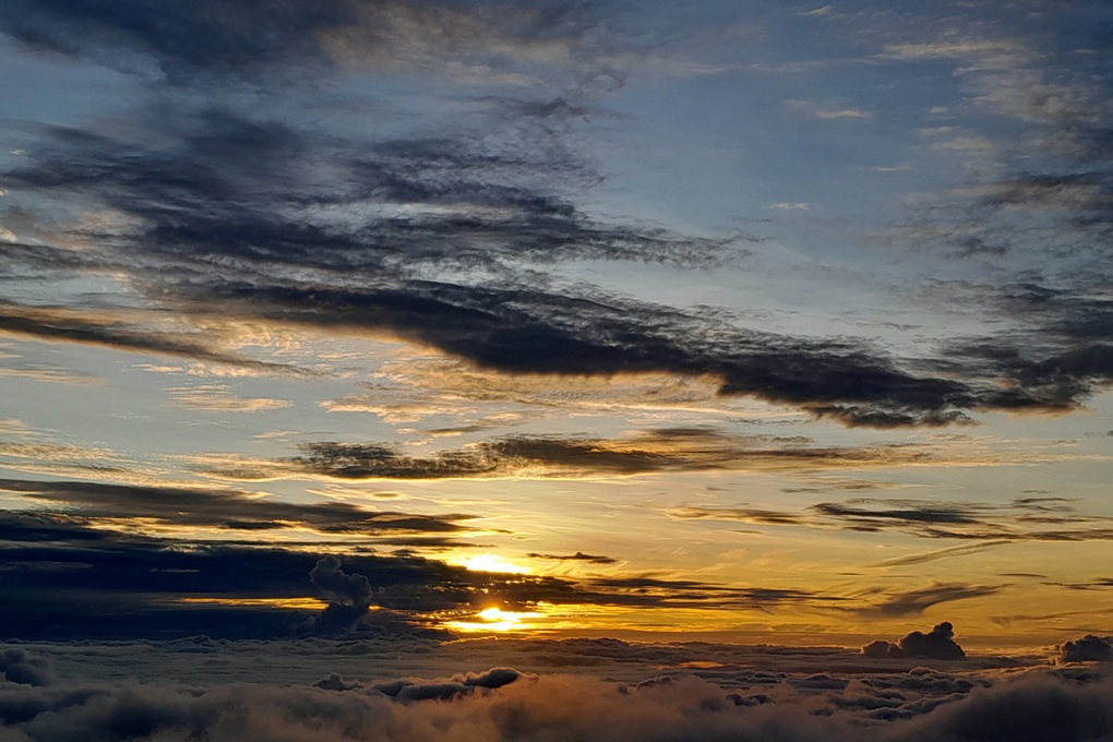 golden sunset in La Réunion, with a cloudy sky and warm light above the clouds