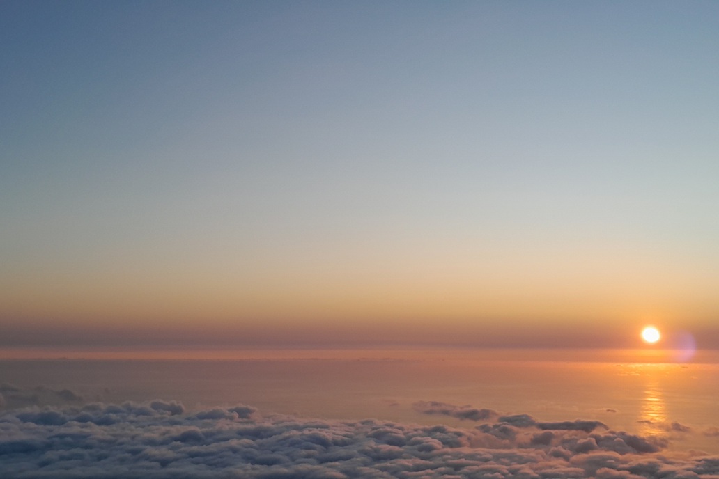 sunset in La Réunion, with a clear horizon and golden reflections on the ocean above a sea of clouds
