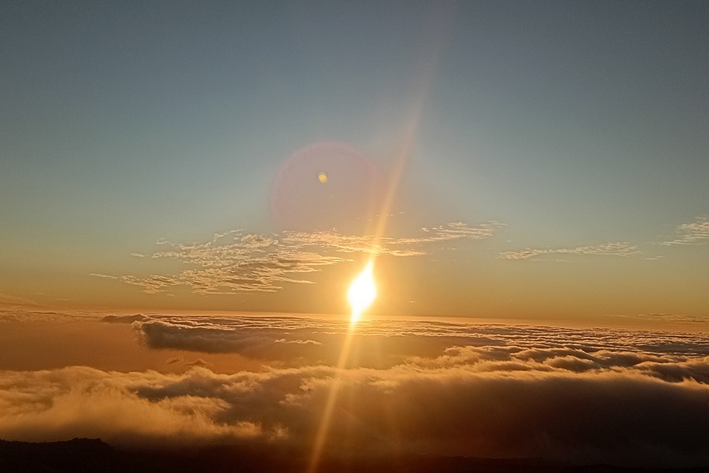 brilliant sunset in La Réunion, with a shining sun and rays of light above the clouds