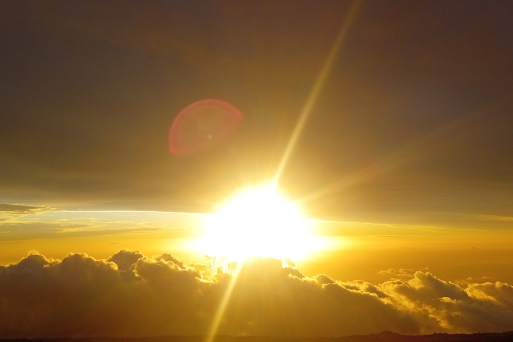 brilliant sunset in La Réunion, with an intense sun above the clouds and radiant golden light