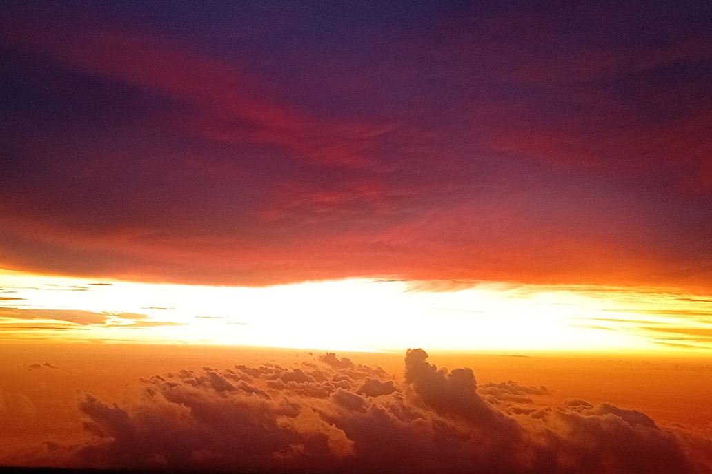 dark sunset in La Réunion, with thick clouds and golden filtered light at the horizon