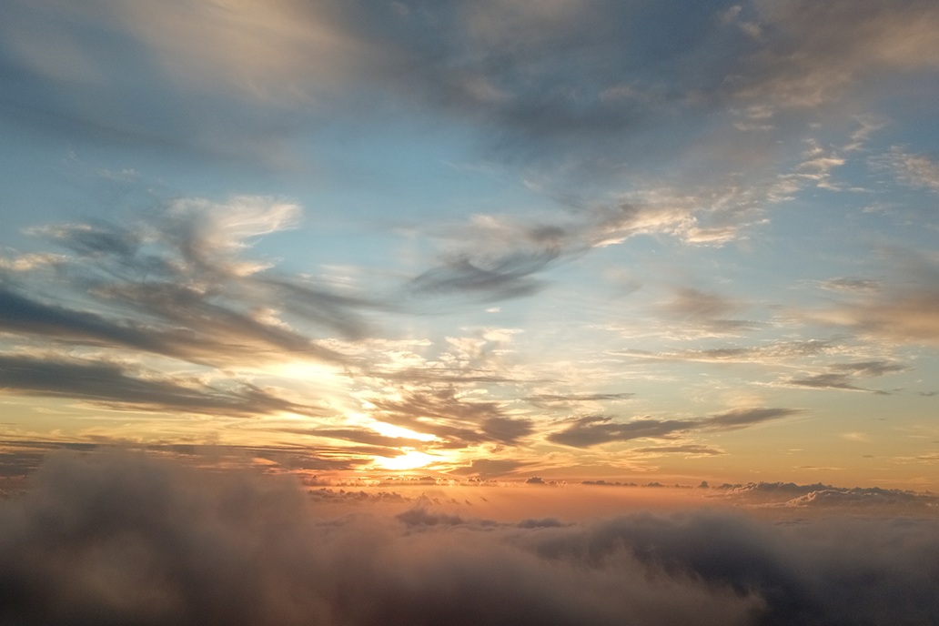 golden sunset above a sea of clouds in La Réunion, with an orange sky and a peaceful atmosphere