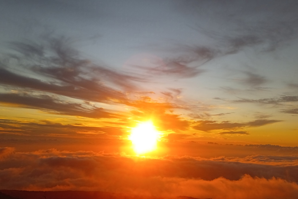intense sunset in La Réunion, with a blazing orange sky and illuminated clouds above the ocean