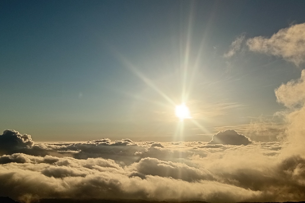 sunset in La Réunion, with a clear horizon and golden reflections on the ocean above a sea of clouds