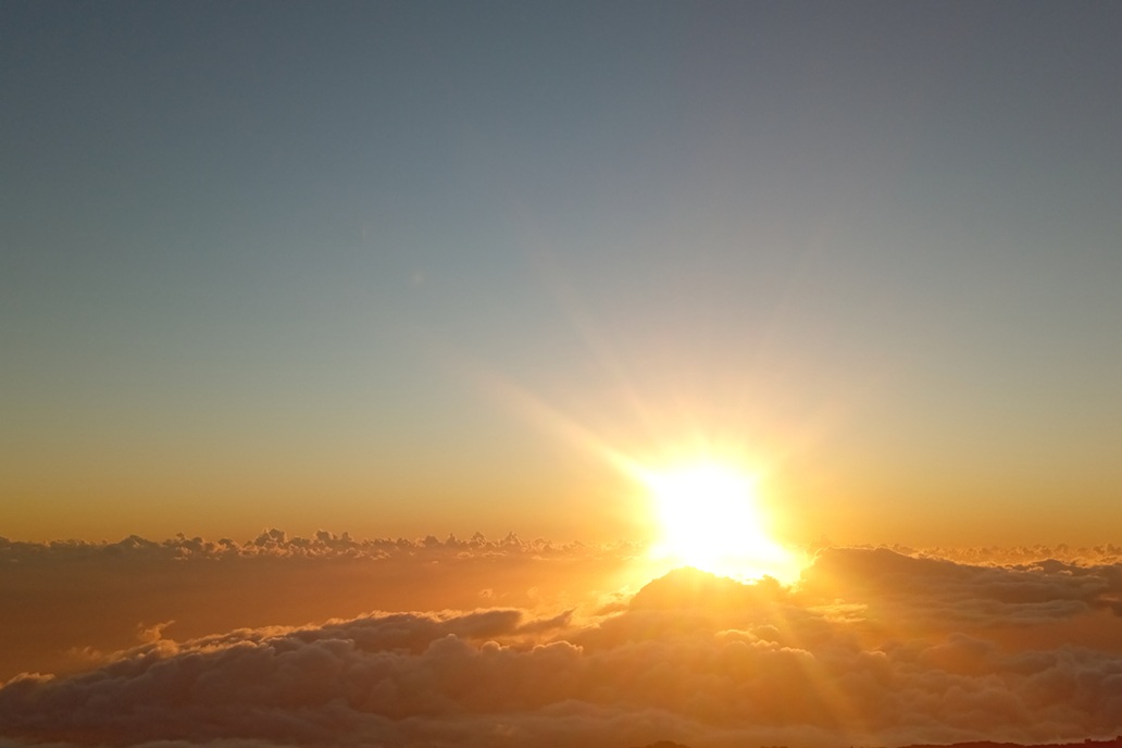 golden sunset in La Réunion, with a diffused sun above a sea of clouds and a soothing sky