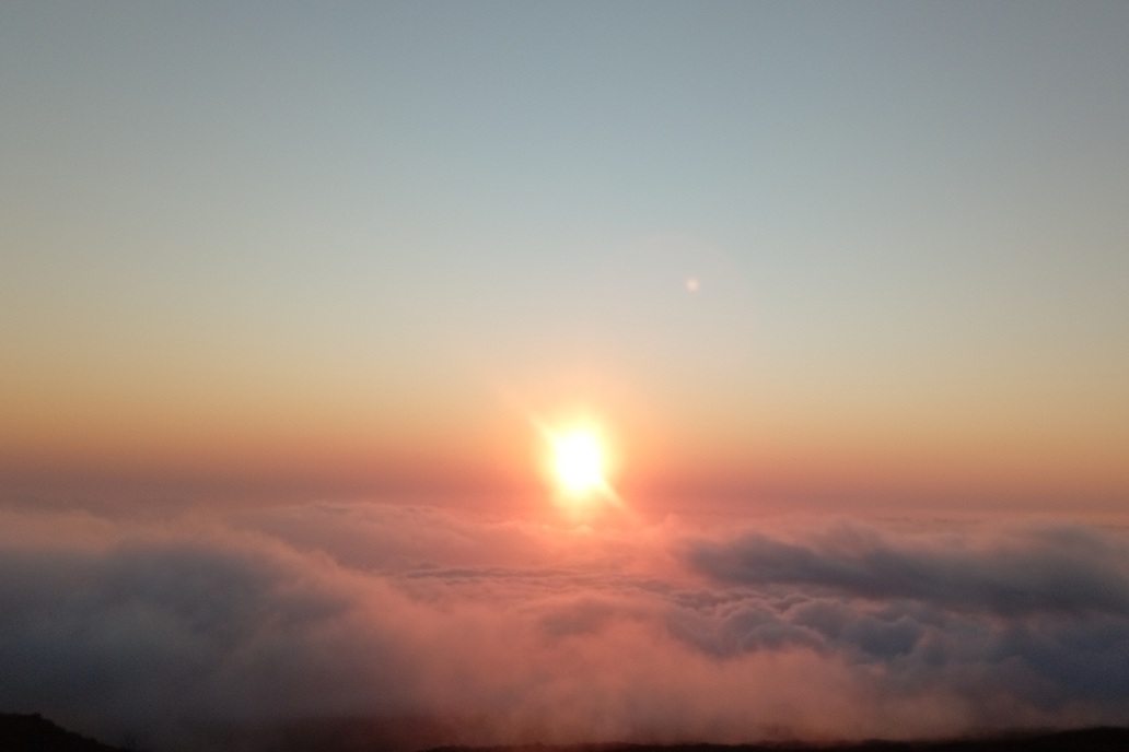luminous sunset in La Réunion, with a diffused sun above the clouds and a soft rosy atmosphere