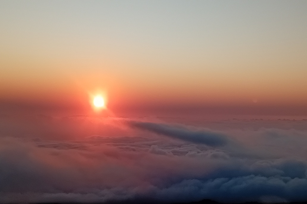 intense sunset in La Réunion, with red-orange light and enveloping clouds above the ocean