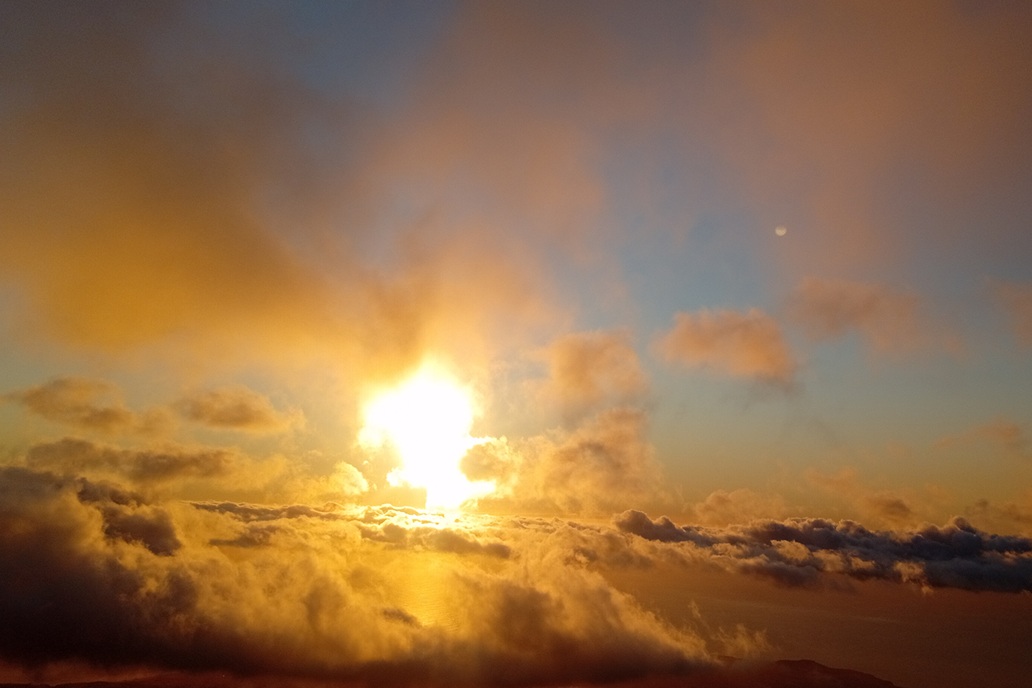 warm sunset in La Réunion, with golden clouds and soft light above the Indian Ocean