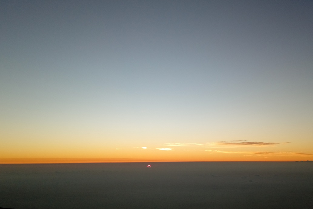 golden sunset in La Réunion, with a diffused sun above a sea of clouds and a soothing sky