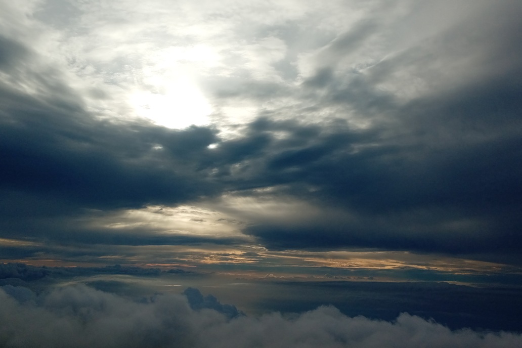 dramatic sunset in La Réunion, with dark clouds and light piercing the sky above the ocean