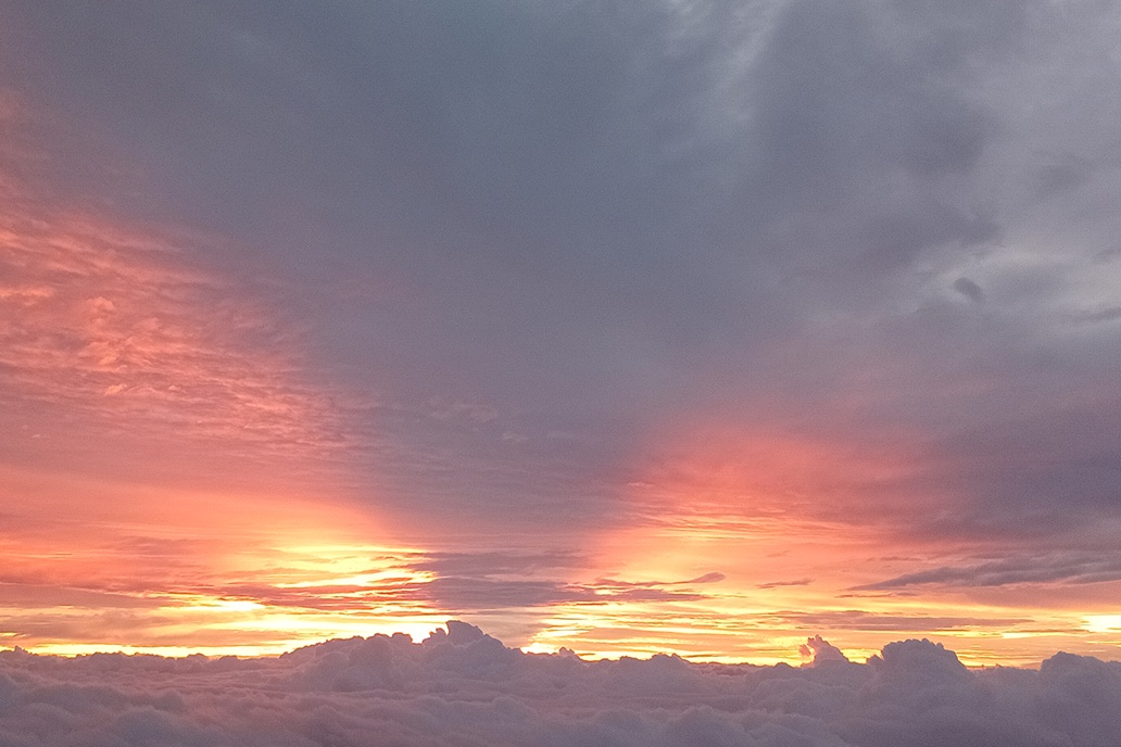 gentle sunset in La Réunion, with a pastel pink and grey sky and clouds spread above the horizon
