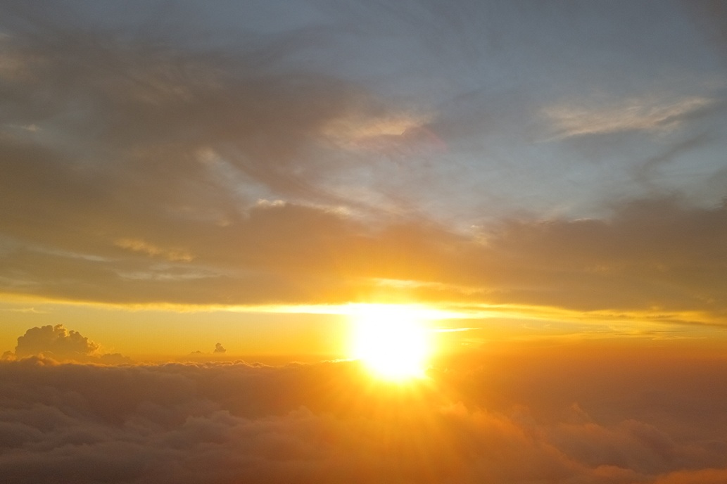 brilliant sunset in La Réunion, with an intense sun and golden light above a sea of clouds